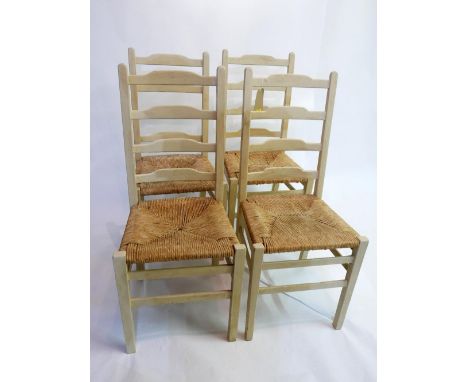 A set of four white painted ladder back dining chairs with rush seats 