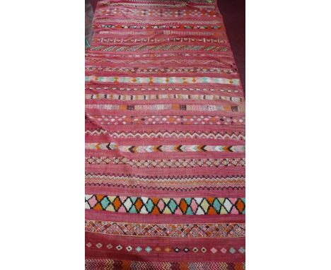 A large 20th century Moroccan kelim carpet, with geometric designs on a red ground, 370 x 182cm 