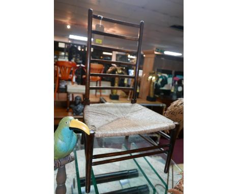 An early 20th century oak ladder back chair with rush seat 