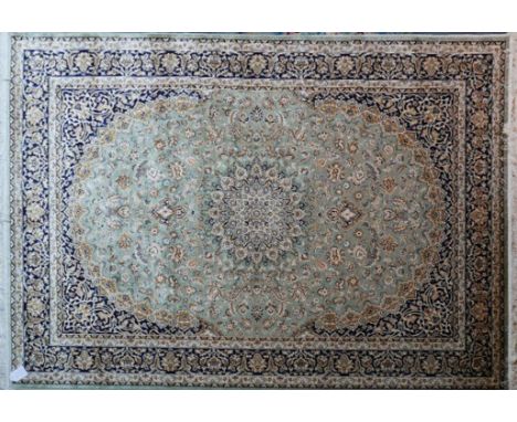 A Kashan style carpet with central floral medallion on a green ground, contained by floral borders, 230 x 160cm 