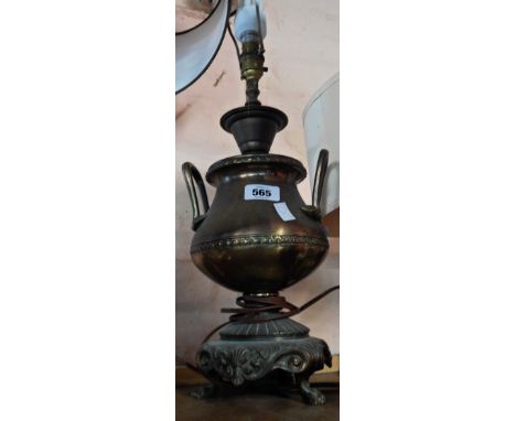 An old brass table lamp of classical two handled urn form on three footed base