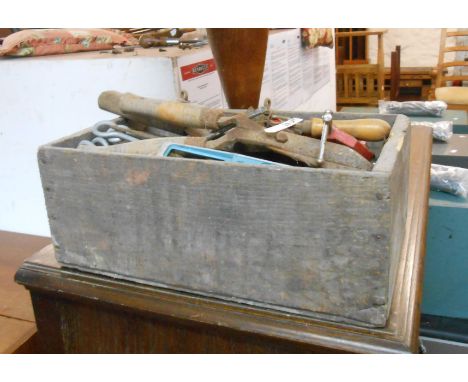 A wooden box containing a quantity of old tools