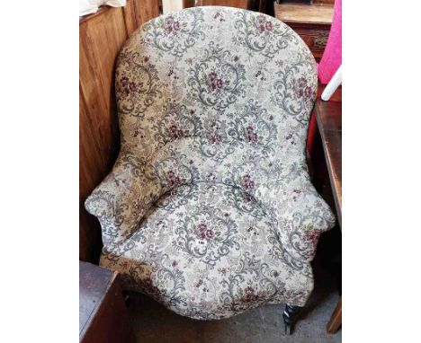A late Victorian drawing room high back tub chair with floral tapestry upholstery, set on ebonised turned front legs and cast