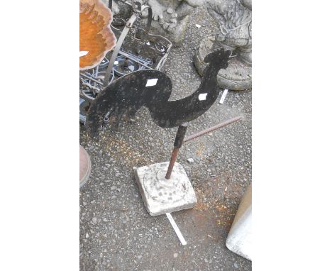 An old wrought iron cockerel form weathervane finial on a marble base