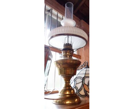 A brass table oil lamp with chimney and shade