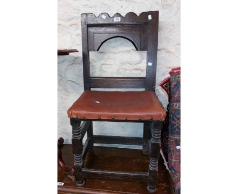 An antique stained oak framed standard chair with moulded and fielded open back and later upholstery, set on ring turned fron