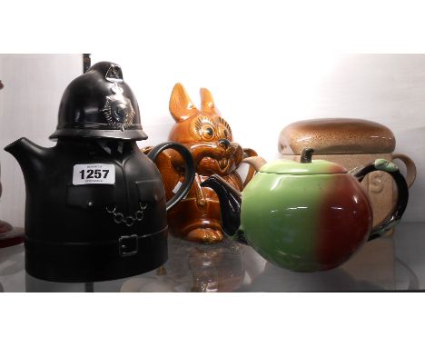 Four novelty teapots comprising Carltonware policeman, apple, Hovis loaf and a comical rabbit