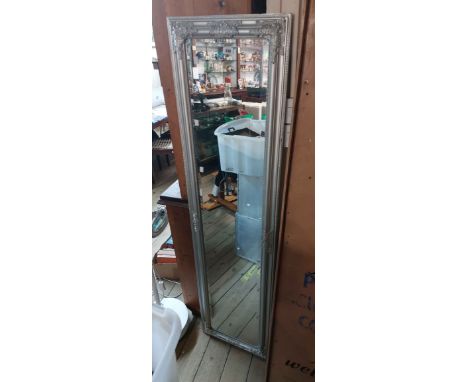A modern ornate silvered framed full length dressing mirror with easel back and bevelled plate