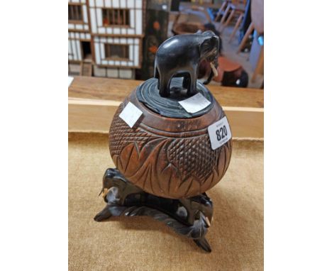 An African carved gourd set on an ebony triple elephant carved base and lid with elephant finial