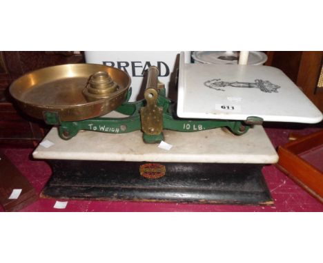 An antique set of scales with marble plinth set on wooden base with cast iron balance, ceramic plate, brass pan and handle ma