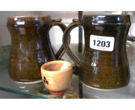 A pair of Lowerdown Jeremy Leach tankards with scroll and thumb rest handles covered in a tenmoku glaze - seal marks to base 