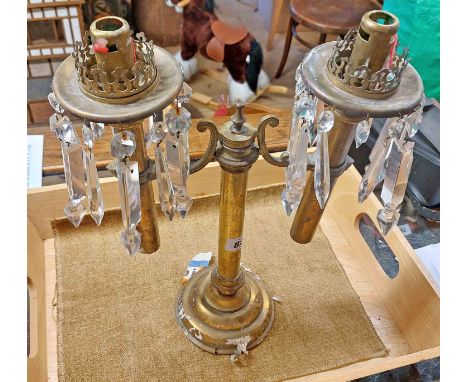 An old brass double spring loaded candle lamp with glass lustre drops