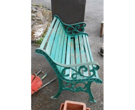 A 20th Century garden bench with decorative scroll cast iron ends and wooden slatted seat - one slat a/f