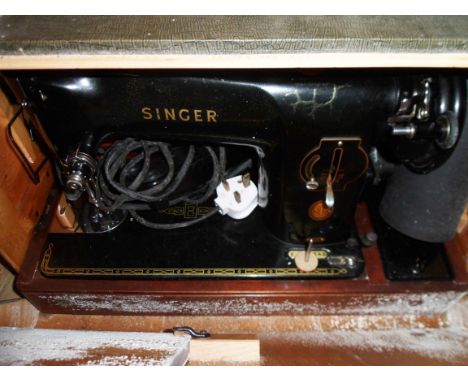 A vintage Singer sewing machine in wooden faux snakeskin case