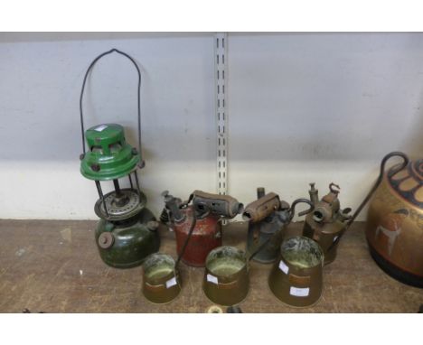 A Tilley lamp, three cider measuring cups and blow torches