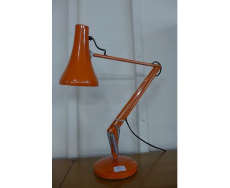 An orange anglepoise desk lamp