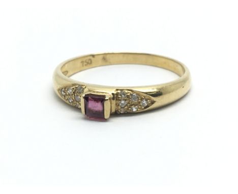 An 18ct yellow gold ring with central ruby surrounded by smaller diamonds, ring size approx N