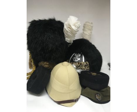 A collection of retrospective Military hats French legion style a bearskin pith helmet and an Essex Regimental cap with badge