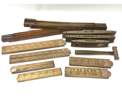 A collection of tools and measures consisting of eight wood and brass rulers, three spirit levels and a brass and copper anti