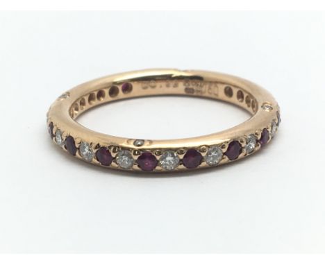 An 18ct rose gold eternity ring surrounded by alternating rubies and diamonds, ring size approx M