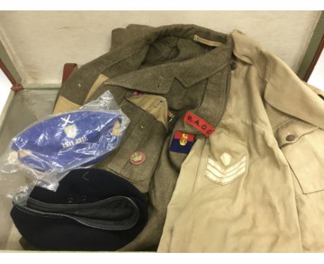 A suitcase containing a collection of army uniform items.