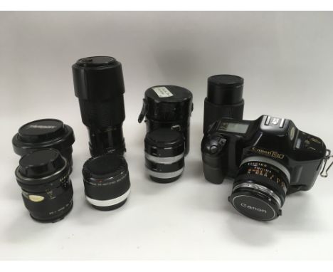 A collection of various Canon camera lenses, a Canon T90 camera and accessories.