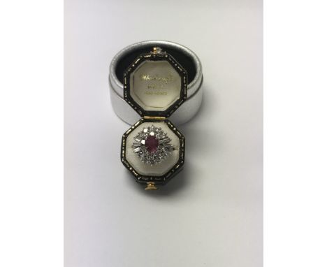 A Art Deco style cocktail ring the central ruby surround by numerous diamonds size L .