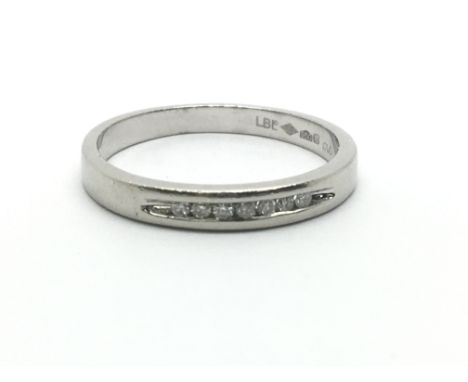 A platinum half eternity ring with a row of seven small diamonds, ring size approx J