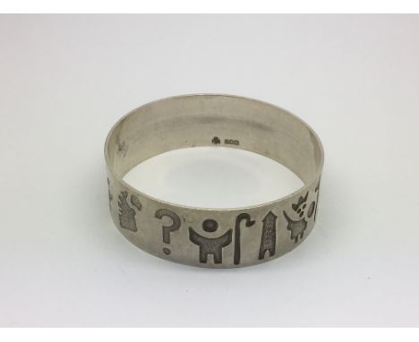 An Irish silver bangle decorated with various symbols, approx 50g.