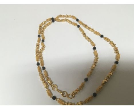 A High grade gold necklace set with alternating patterned links and small sapphire. Total weight 37g