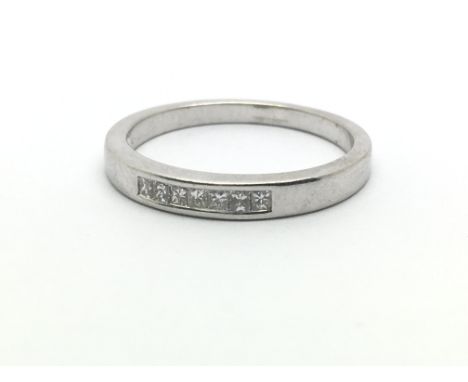 An 18ct white gold and diamond ring, having seven small princess cut diamonds, ring size approx N