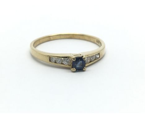 A 14ct ring, the central sapphire flanked by six small diamonds, ring size approx N/O