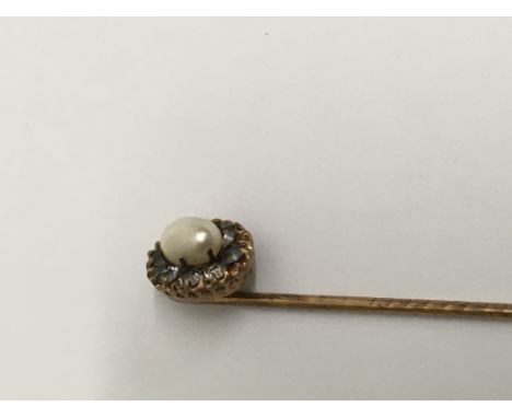 A Edwardian stick pin inset with pearl and old cut diamonds.