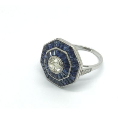 A platinum octagonal sapphire and diamond ring set with a central old cut diamond, approx 0.65ct, surrounded by two halos of 