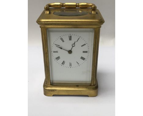 A brass case carriage clock the enamel dial with Roman numerals striking on a gong . With key .