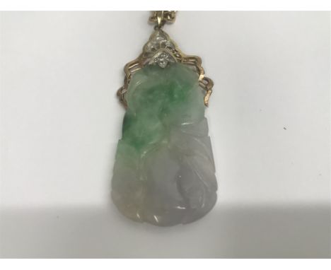 A jade pendant with gold and diamond mount on a 14 ct gold chain marked 585. 24 grams.