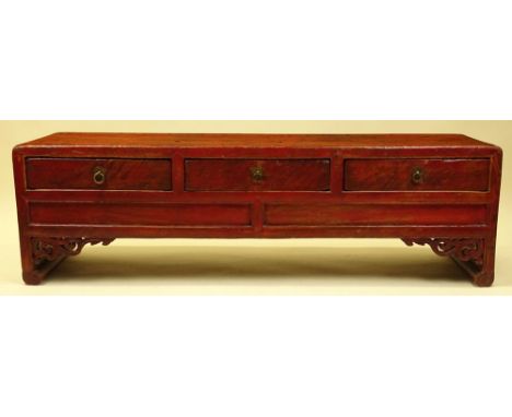 Antique Chinese red polychromed carved wood low bench cabinet. Three drawers. Unsigned. Distressed finish consistent with age