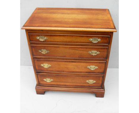 A yew wood and crossbanded chest of four long graduated drawers with carved brass drop handles on bracket feet, 75 x 65 x 39c