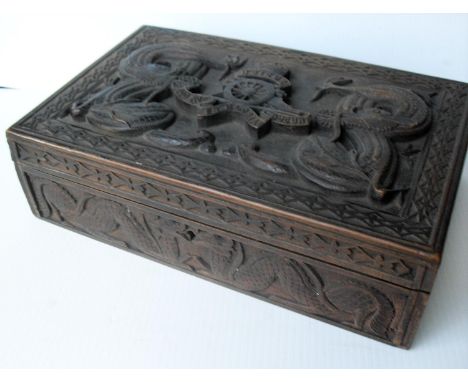 An Indian carved hardwood jewellery box with Royal Artillery insignia to top, 'ubique quo fas et gloria ducunt', fitted inter