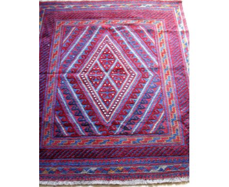 An Afghan tribal hand-knotted  burgundy Kazak wool rug with multi-coloured lozenge decoration, double borders and short fring