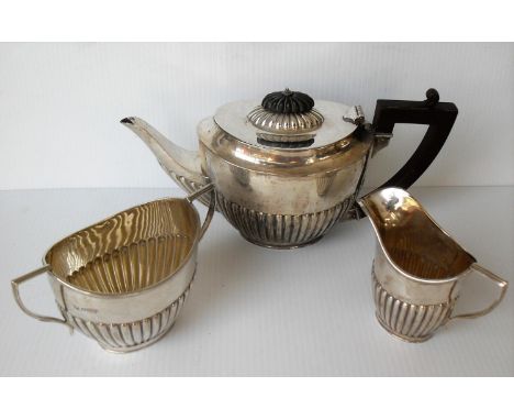 An Edwardian silver three-piece bachelor tea service of oval form, half-fluted decoration, reeded handles by Richard Martin &