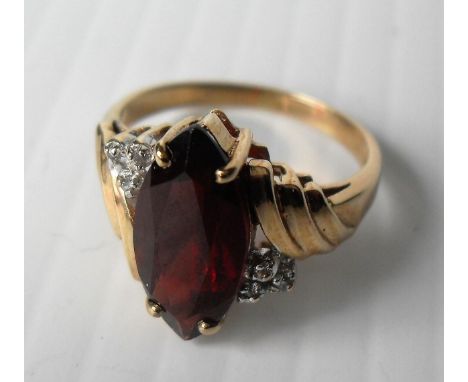 A 9ct yellow gold marquise-cut garnet ring with diamond accents in a cage setting, size M, hallmarked 9K, 3.5g 