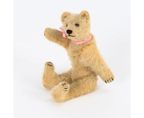 Kleiner Teddy Steiff. Ungemarkt.  Um 1930. L 19 cm.  Blonder Mohairbär mit drehbarem Kopf, braunen Glasaugen und schwarz best