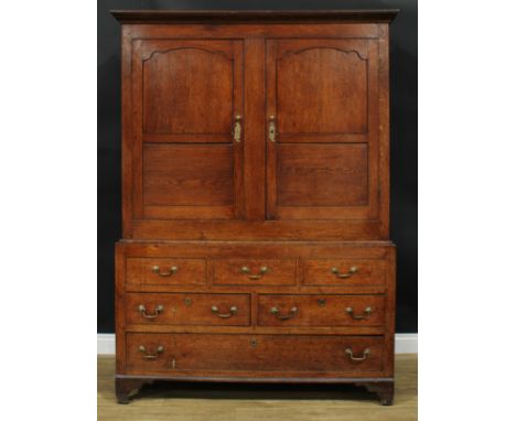 A George III oak housekeeper’s livery or provision cupboard, moulded cornice above a pair of panel doors enclosing hooks, the