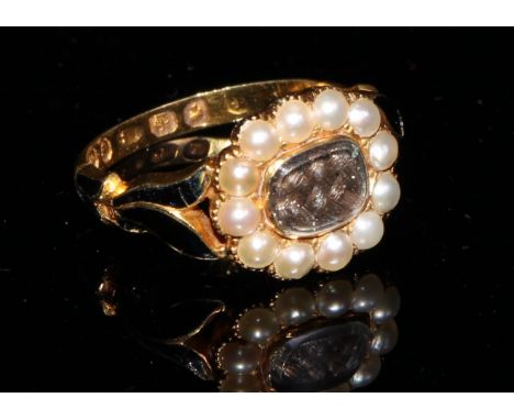 A Victorian 18ct gold mourning ring, set with a plaited and waxed lock of hair, surrounded by twelve seed pearls as a flower 