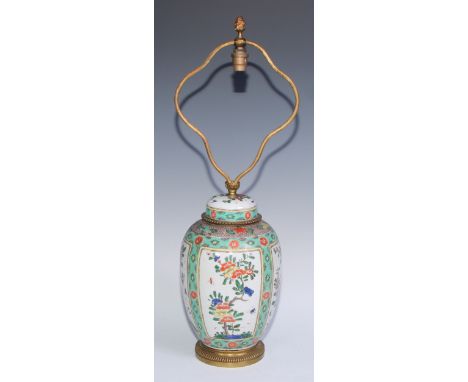 A Chinese famille verte ovoid vase and cover, painted with flowering branches within rectangular reserves, on a green ground 