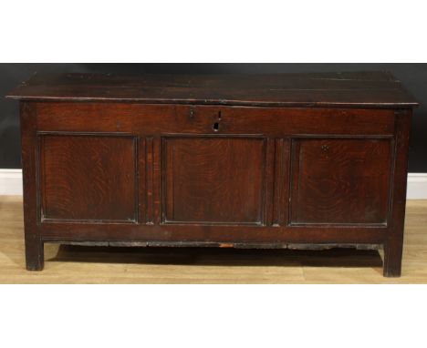 A Charles II oak blanket chest, hinged top above a three panel front, stile feet, 65cm high, 142cm wide, 53cm deep, c.1675 