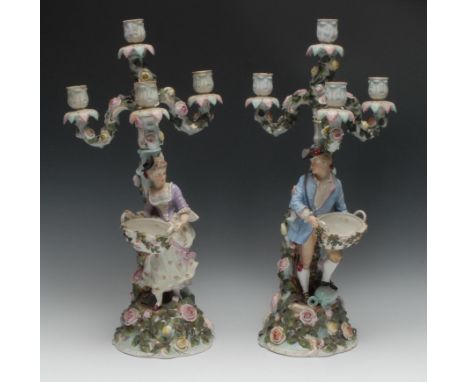 A pair of 19th century Continental porcelain figural four-light, three-branch candelabra, as flower pickers, they both stand 