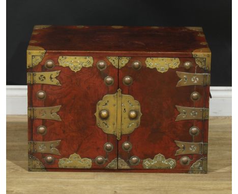 A Chinese brass mounted enclosed table cabinet, flush rectangular top above a pair of yumu veneer panel doors enclosing an ar