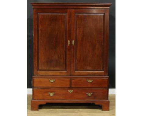 A George III mahogany linen press, outswept cornice above a pair of raised and fielded panel doors enclosing a sliding tray, 